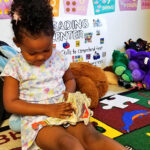 Girl reading a book at Childcare Center and daycare at New Beginnings